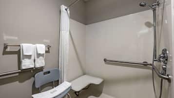 A bathroom with a shower, a grab bar, a bench, and a chair.