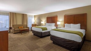 A hotel room with two beds, a sofa, a desk, and a window with curtains. - Comfort Inn Collinsville near St. Louis (Collinsville)
