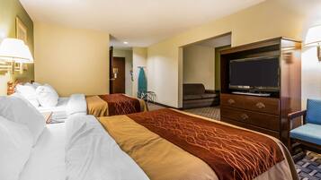 Quarto de hotel com duas camas, televisão, secretária e uma cadeira.