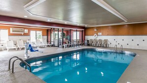 An indoor swimming pool with lounge chairs and a sunbed. - Quality Inn & Suites Evansville North (Evansville)