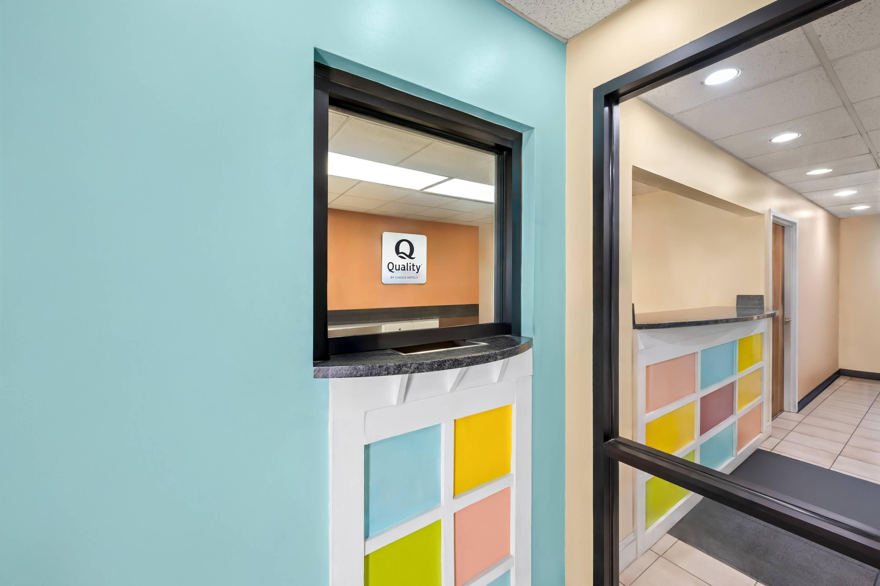 A hotel reception area with a sign indicating 'Quality by Choice Hotels.'
