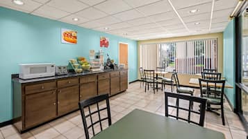 A clean, well-lit cafe with a counter, seating area, and a view of the outdoors.