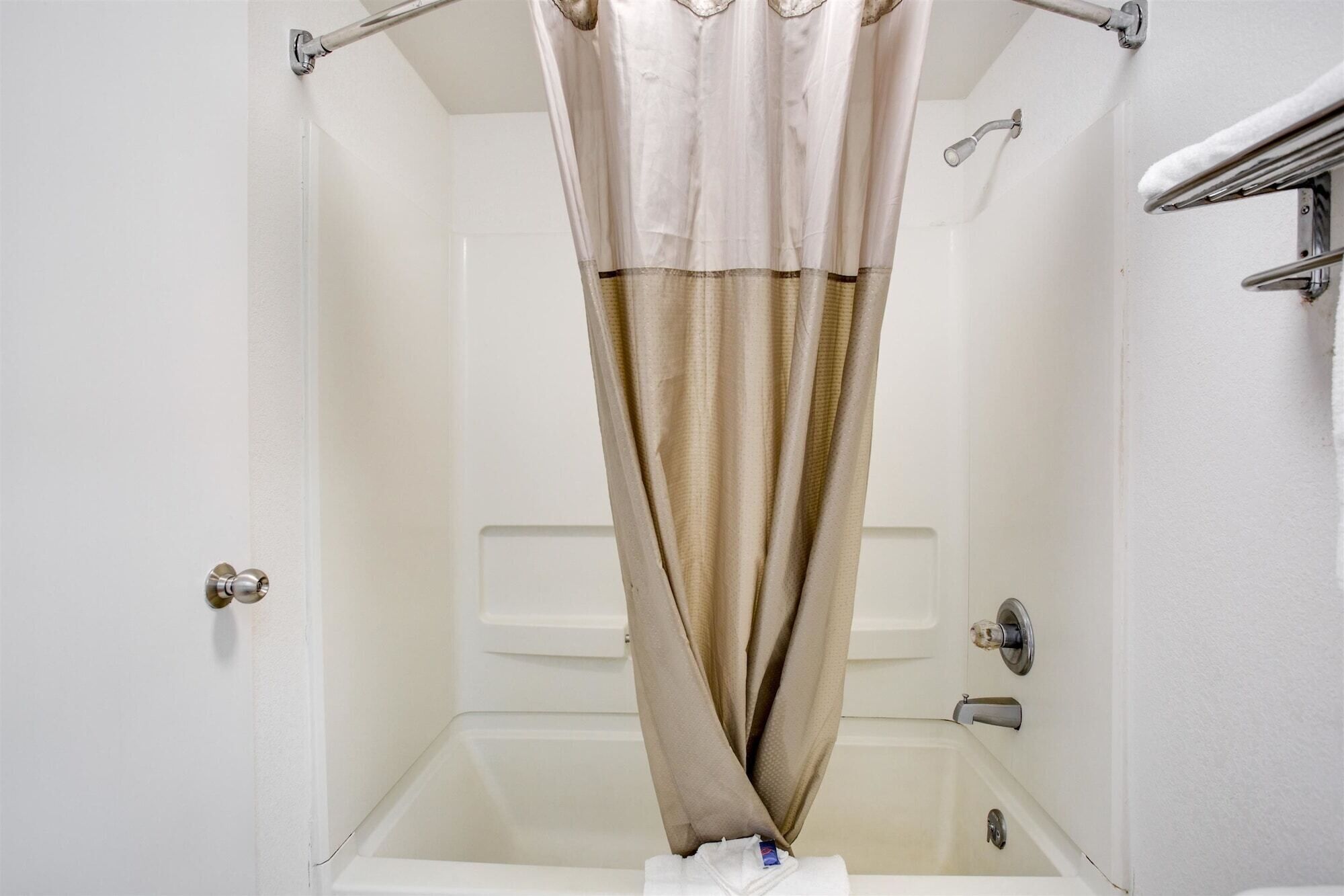 Une salle de bain avec une baignoire, un rideau de douche et un porte-serviettes.