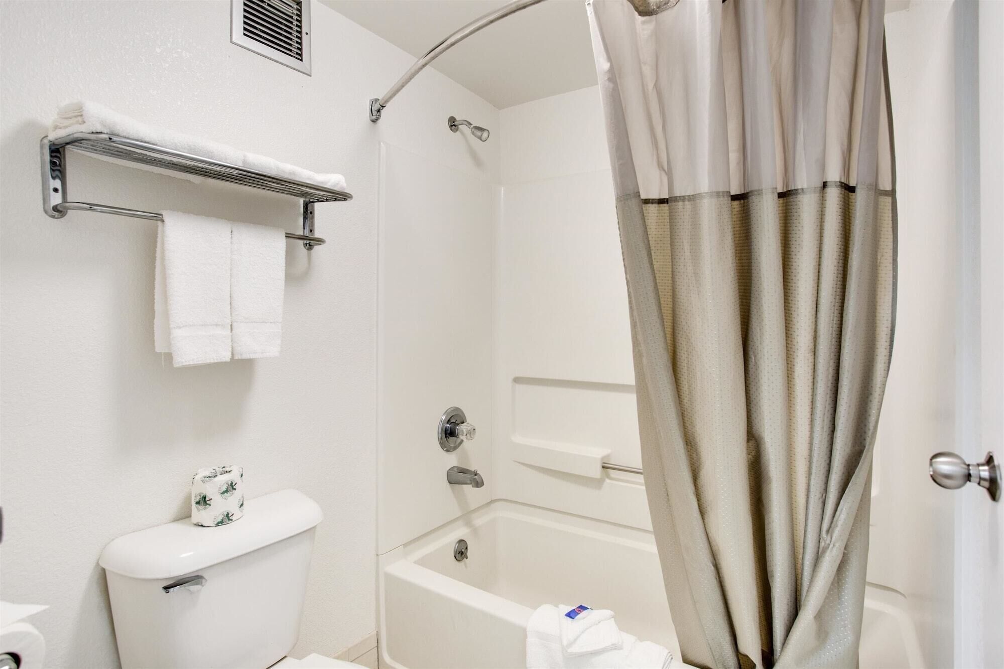 A bathroom with a toilet, a shower, and a bathtub.