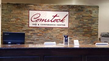 Una recepción en Comstock Inn & Conference Center, con un fondo de pared de piedra y un cartel.