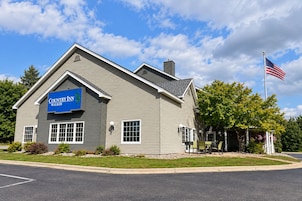 Edificio del Country Inn Walker con cielo despejado, una bandera estadounidense y un césped bien cuidado.