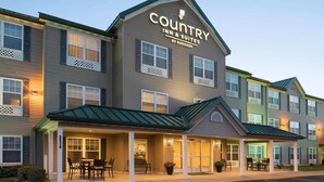 Ein Country Inn & Suites by Radisson Hotelgebäude mit überdachter Veranda und zahlreichen Fenstern.