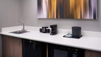 A modern kitchen with a built-in dishwasher, a coffee maker, and a microwave.