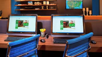 A workspace with two laptops on a desk, a keyboard, a mouse, and a chair.