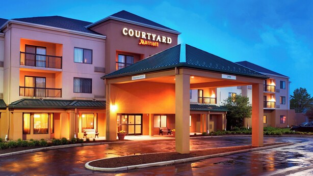 A Courtyard Marriott hotel with a covered entrance, multiple balconies, and a well-lit facade. - Courtyard by Marriott Cleveland Airport North (North Olmsted)