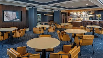 Relax in our spacious lobby, featuring comfortable seating areas, a bar, and artwork on display.