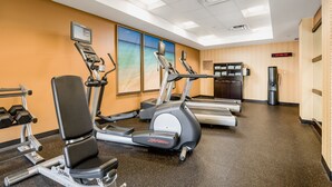 A gym with treadmills, an elliptical, and dumbbells. - Courtyard by Marriott Gulf Shores Craft Farms (Gulf Shores)