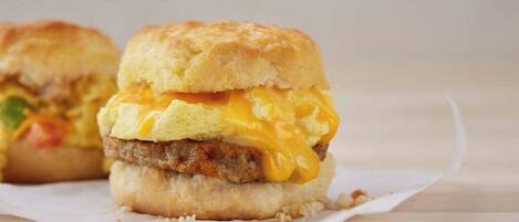 Un sándwich de desayuno con un panecillo, huevo y queso fundido.
