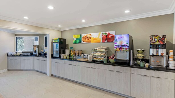 Een moderne hotelontvangst met een balie, een koffieapparaat en een sapautomaat.