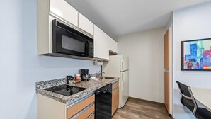 A compact kitchen with a microwave, coffee maker, and dishwasher. - MainStay Suites Cincinnati Blue Ash (Cincinnati)