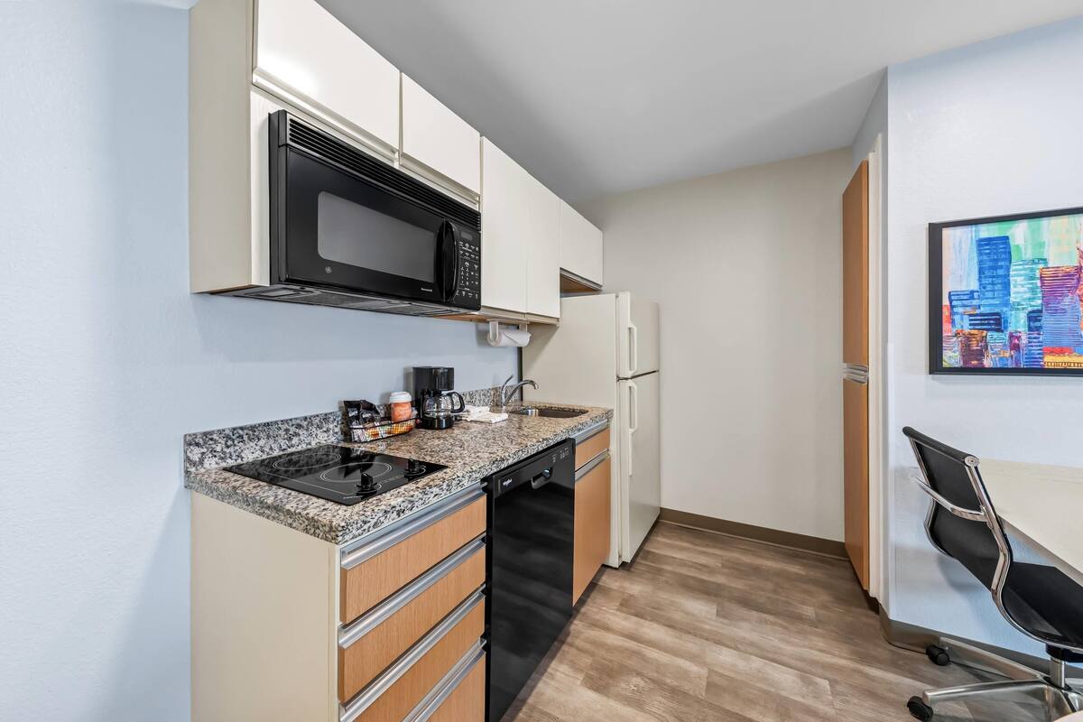 A compact kitchen with a microwave, coffee maker, and dishwasher.