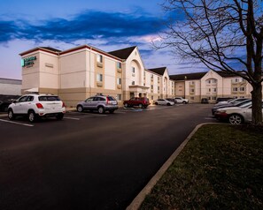 A MainStay Suites hotel with a parking lot and multiple vehicles. - MainStay Suites Cincinnati Blue Ash (Cincinnati)