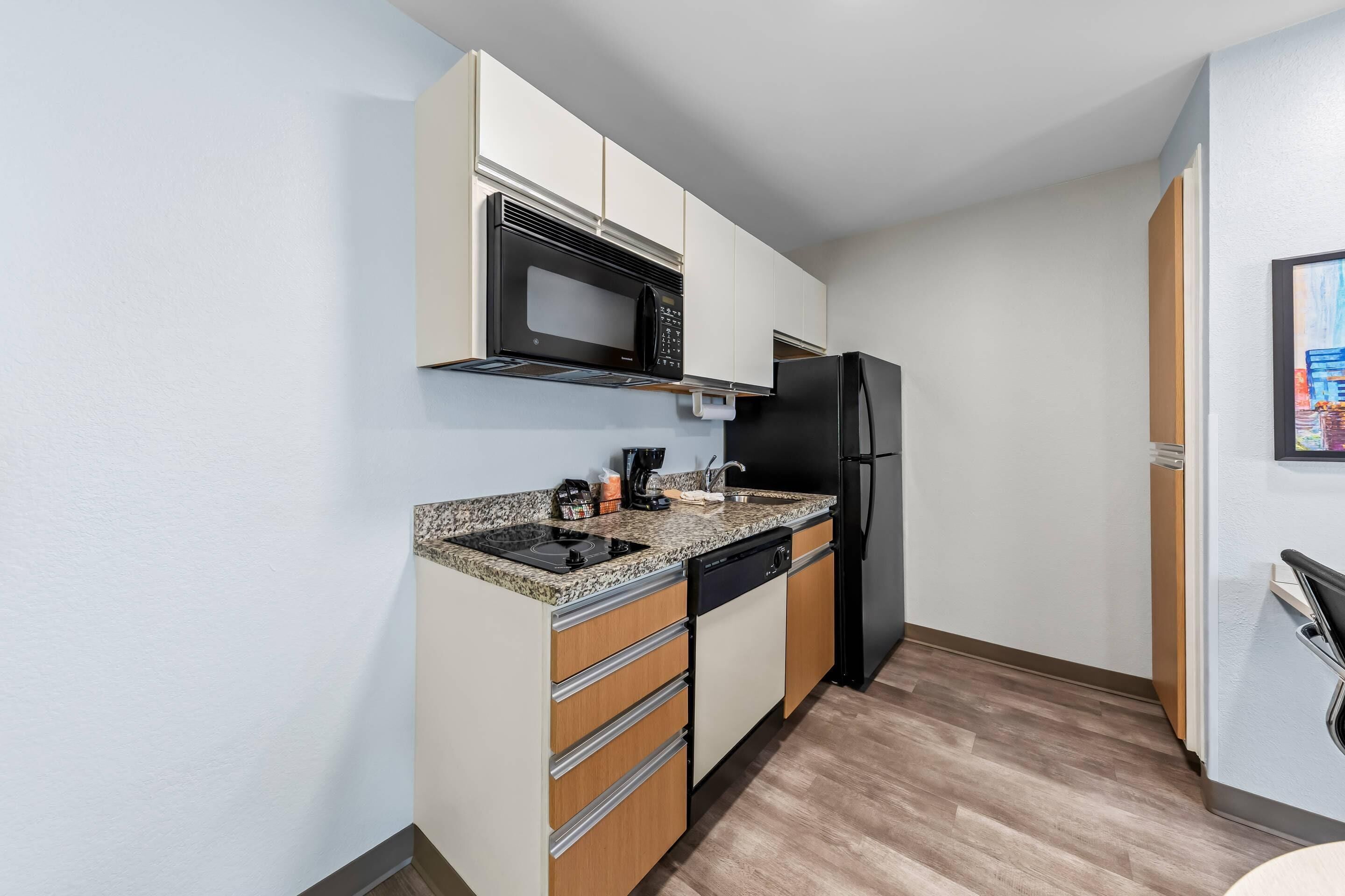 A compact kitchen with a microwave, refrigerator, and dishwasher.