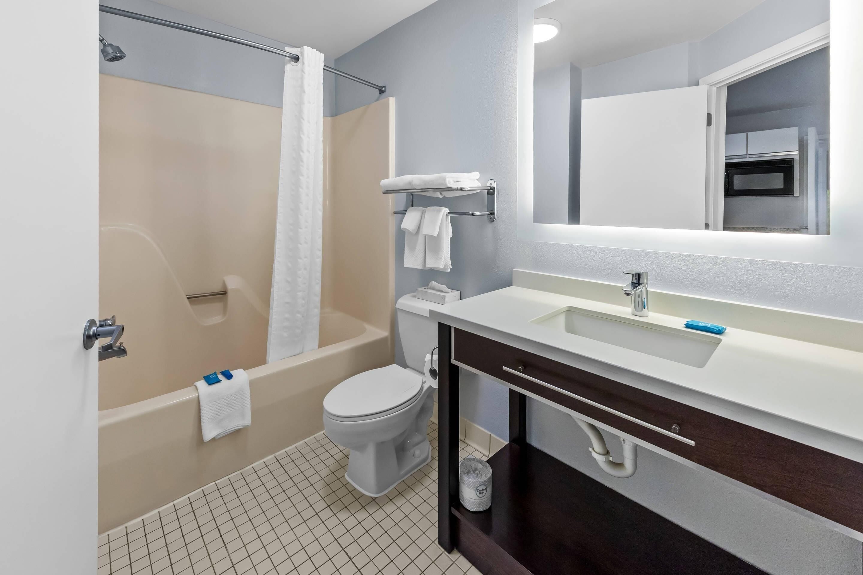 A modern bathroom with a bathtub, toilet, and sink.