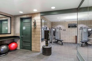 A gym with exercise equipment, a punching bag, and a mirror. - Best Western Plus Sundial (Scottsdale)