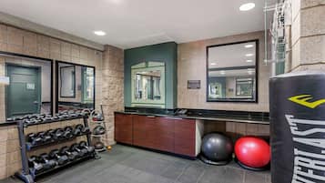 Ett gym med en spegel, en boxningssäck, hantlar och träningsbollar.