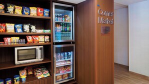 Ein Getränke- und Snackautomat, platziert in einer Ecke eines Raumes mit Holzvertäfelung.
