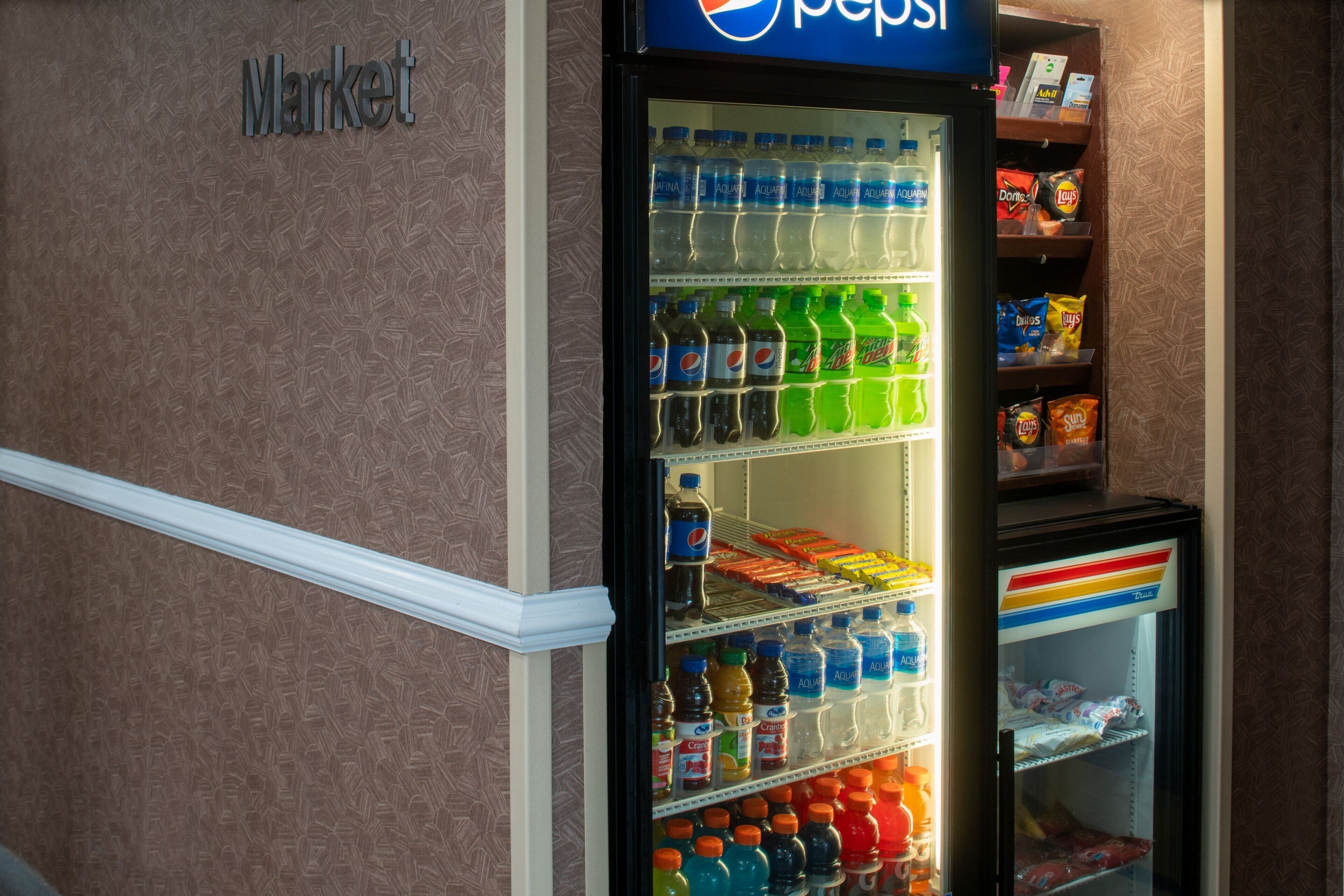 A vending machine stocked with various beverages and snacks, including Pepsi, Aquafina, and Doritos.