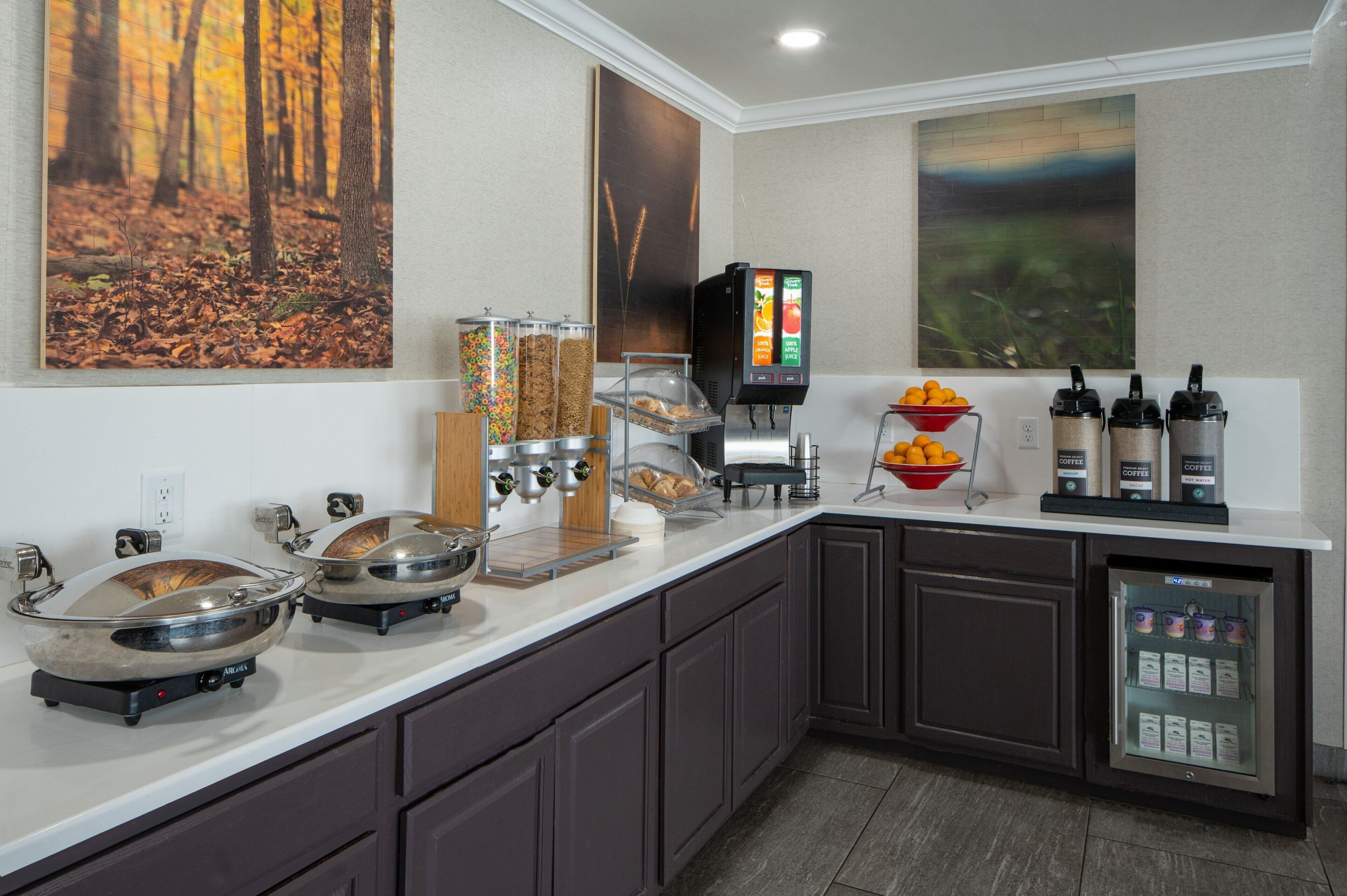 A breakfast bar with a coffee machine, cereal dispensers, and a fruit bowl.