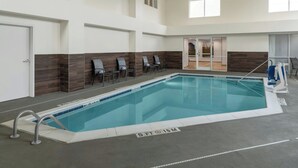 Una piscina interior con una profundidad de 1,5 metros, sillones de descanso cercanos y una vista despejada del área de la piscina.
