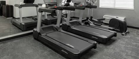 A fitness center with treadmills, elliptical machines, and a stationary bike.