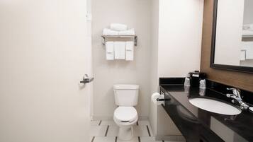 A modern bathroom with a toilet, sink, and towel rack.