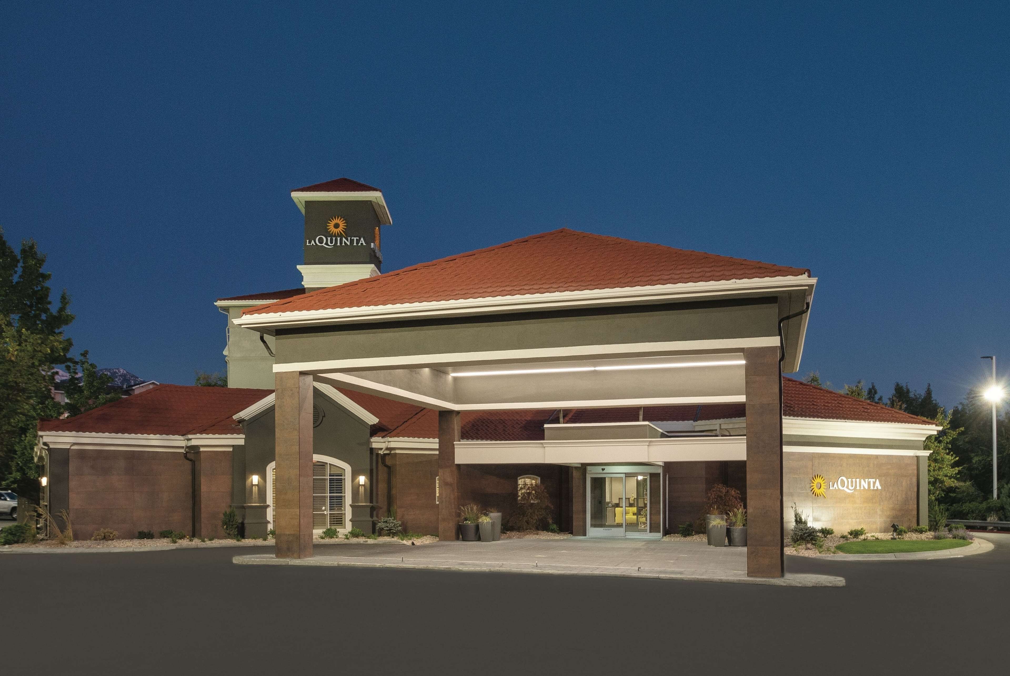 A hotel with a covered entrance, a red roof, and a sign reading "La Quinta".