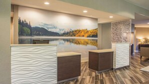 A reception area with a large scenic mural, a reception desk, and a decorative partition.