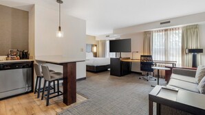 A hotel room with a kitchenette, a bed, a desk, a sofa, and a TV. - Sonesta ES Suites Fairfax Fair Lakes (Fairfax)