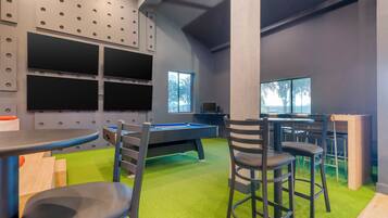 Relax in this spacious room with a pool table, comfortable seating, and a large window offering a view.