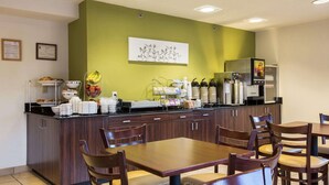 Un bar pour le petit-déjeuner avec des sièges, un réfrigérateur et une machine à café.