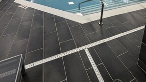 An indoor swimming pool with clear lane markings, a lifeguard chair, and safety signs. - Spark by Hilton Grand Rapids (Grand Rapids)