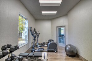 A gym with exercise equipment, a bench, dumbbells, and a large exercise ball. - Holiday Inn Express Hotel & Suites Oshkosh by IHG (Oshkosh)