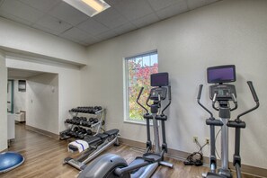 A gym with treadmills, an elliptical, and dumbbells. - Holiday Inn Express Hotel & Suites Oshkosh by IHG (Oshkosh)