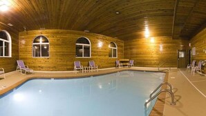 An indoor swimming pool with wooden walls and arched windows, surrounded by lounge chairs. - Holiday Inn Express Tuscola by IHG (Tuscola)