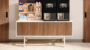 A kitchen area with a wooden cabinet, a coffee machine, and various storage containers. - Holiday Inn Express Tuscola by IHG (Tuscola)