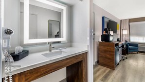 A modern bathroom with a large mirror, white sink, and wooden vanity. - Comfort Inn & Suites Ogallala (Ogallala)