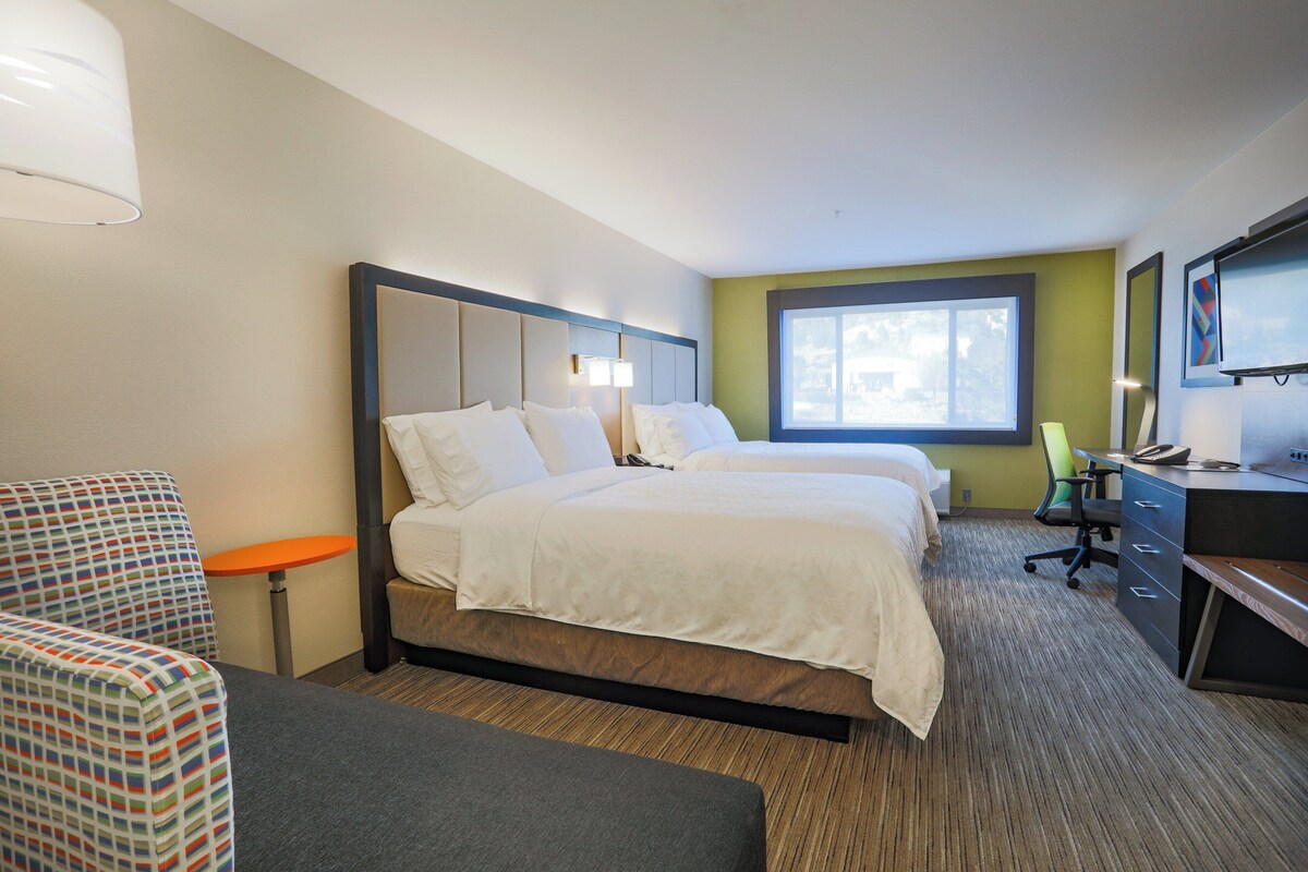Une chambre d’hôtel équipée d’un lit, d’un bureau, d’une chaise, d’une lampe et d’un téléviseur.