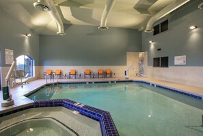 An indoor swimming pool with a lifeguard station, chairs, and a tiled wall. - Holiday Inn Express Prescott by IHG (Prescott)