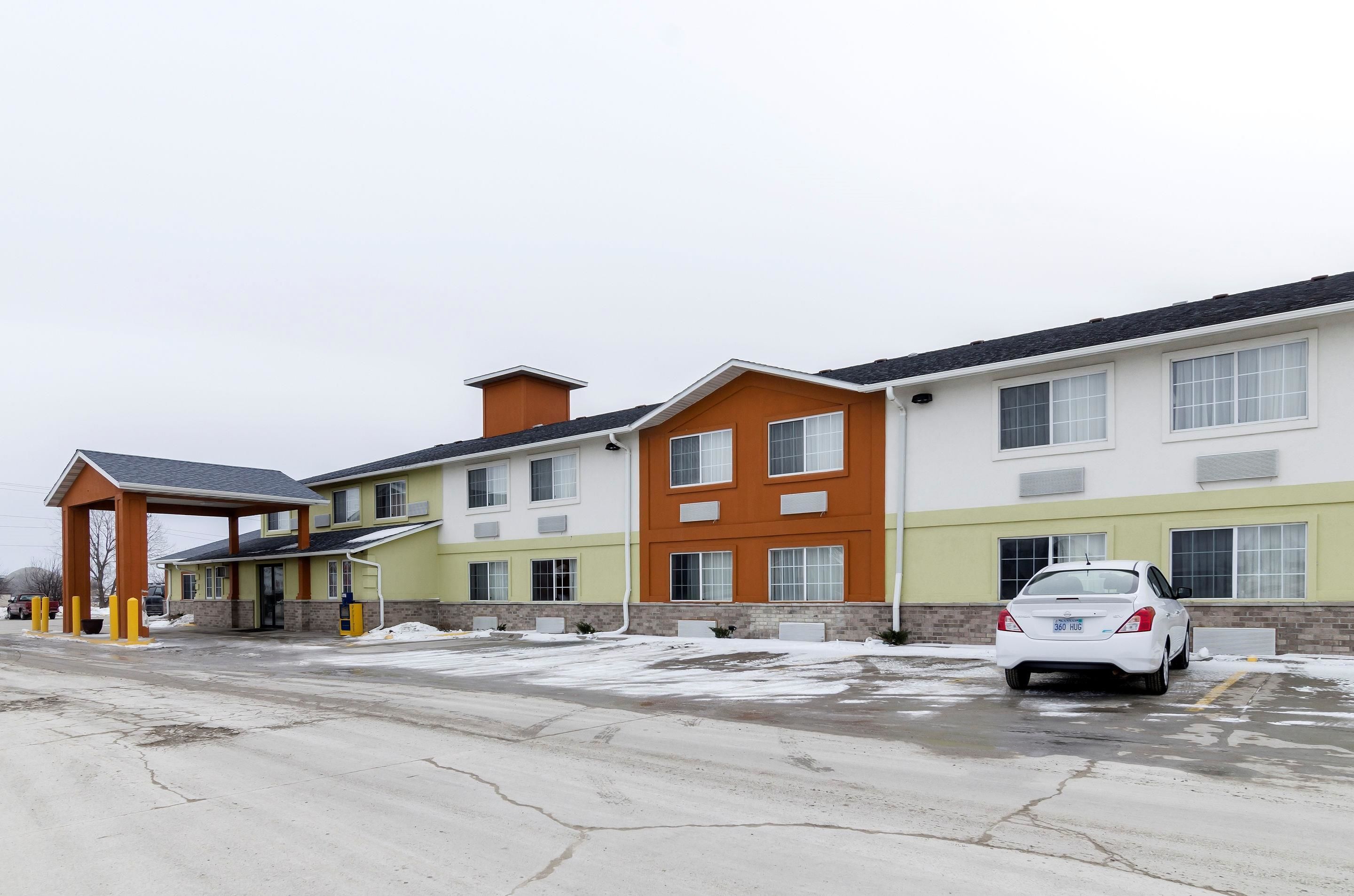 A multi-story hotel with a parking lot and a covered entrance.