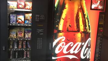 A vending machine with a Coca-Cola advertisement and various snack options.