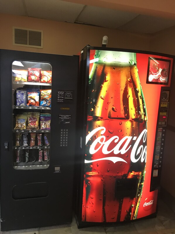 A vending machine with a Coca-Cola advertisement and various snack options.