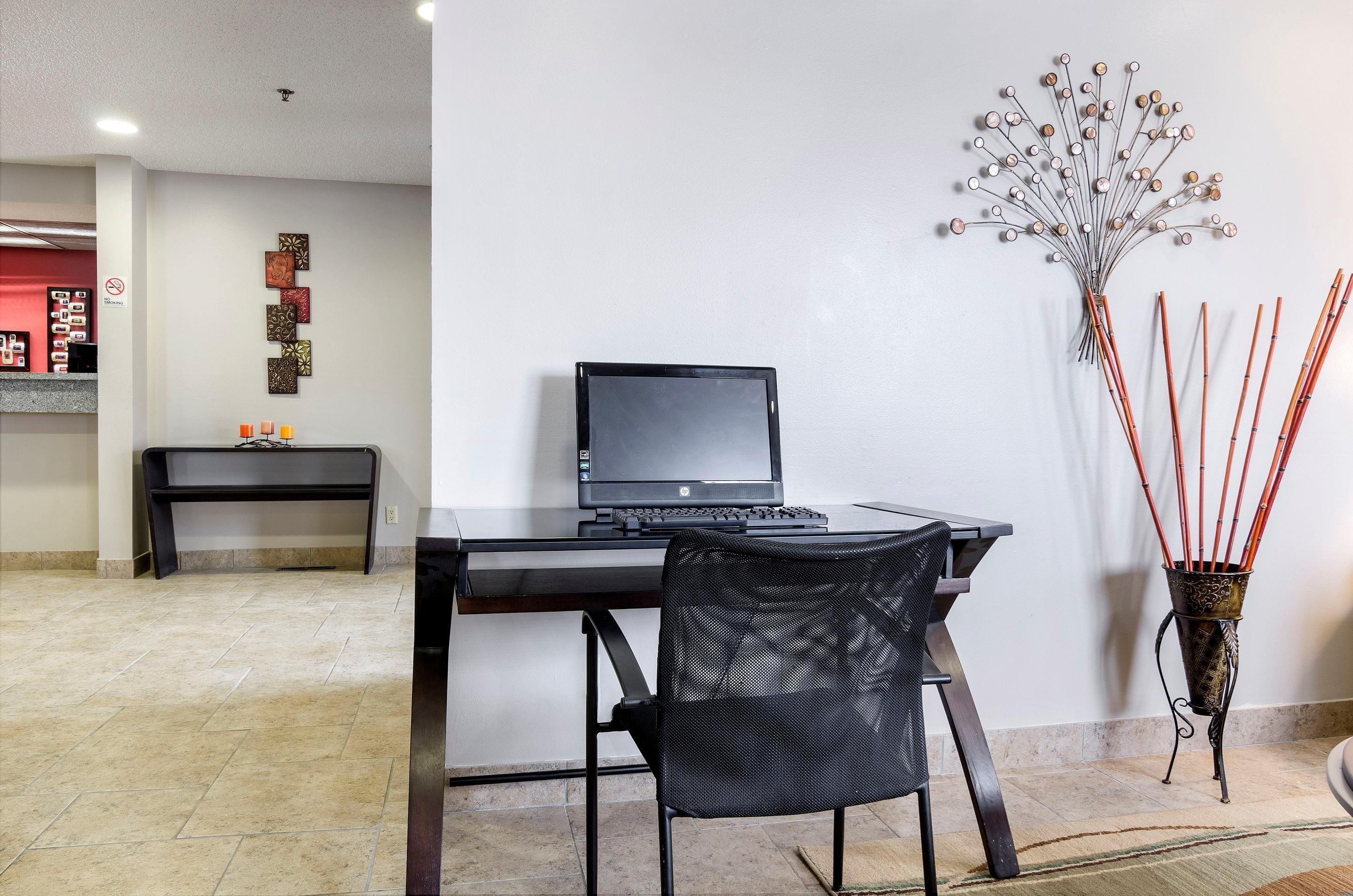 Un espacio de oficina moderno con un escritorio, una silla y una planta decorativa.