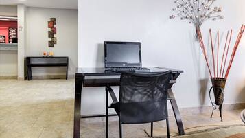 Un espacio de oficina moderno con un escritorio, una silla y una planta decorativa.