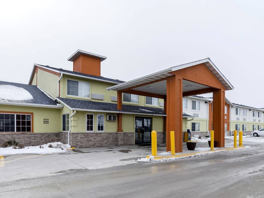 A multi-story hotel with a covered entrance and a parking lot.
